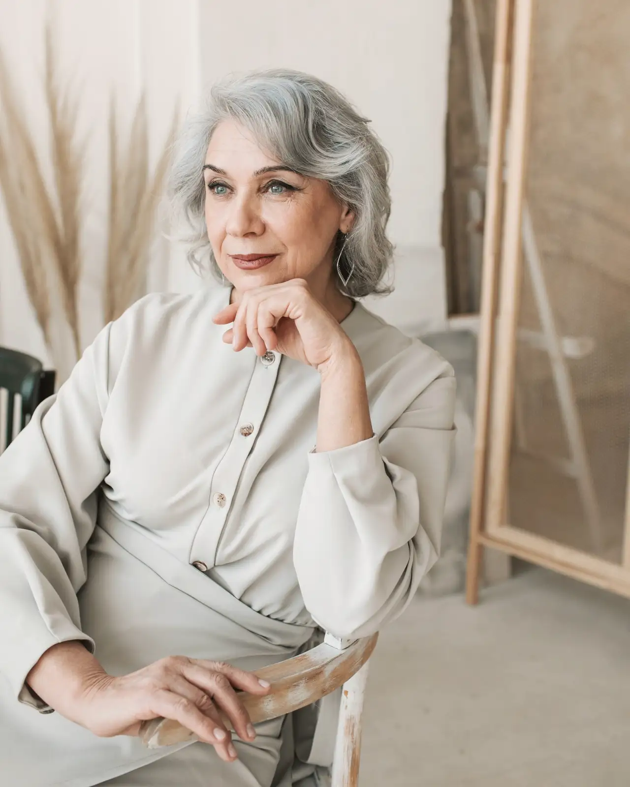 Woman with silver hair sitting by a window