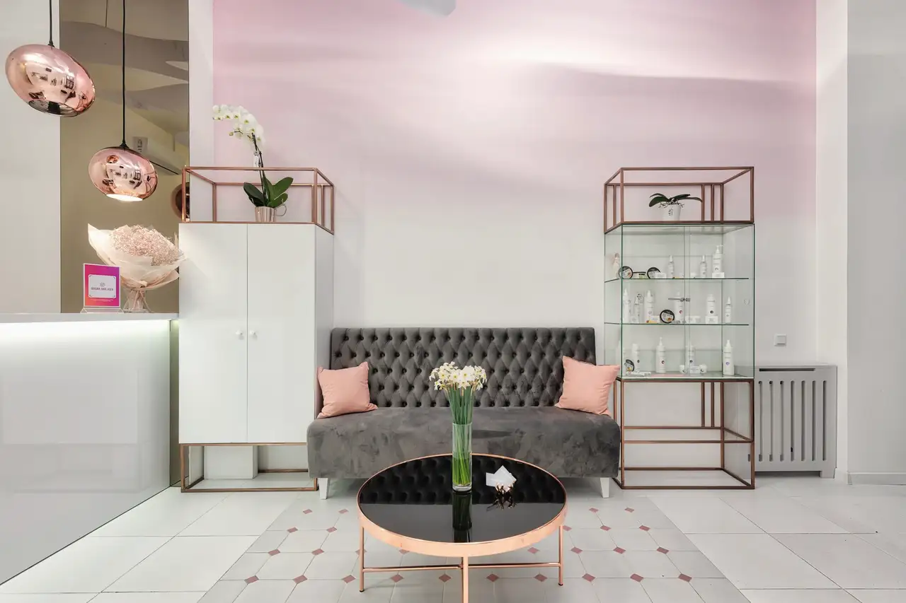 Calm clinic lounge with a soft sofa, a glass cabinet and flowers on a low table